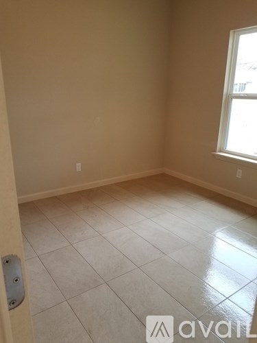 A room with a tile floor and a window letting in light.