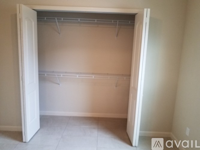 A white closet with a white door is open.