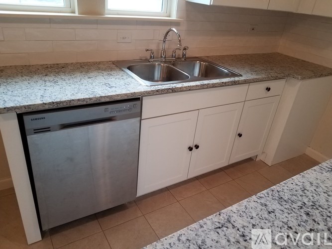 A kitchen with a granite countertop and a dishwasher.