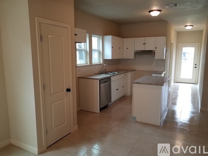 A kitchen with white appliances and cabinets is available for rent.