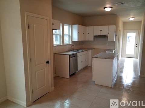 A kitchen with white appliances and cabinets is available for rent.
