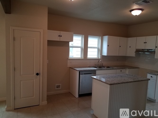 A kitchen with a white door and a brown counter top.