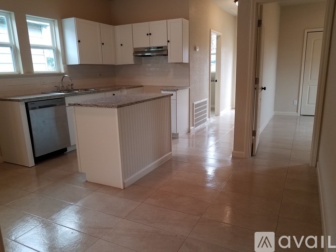 A kitchen with white cabinets and a tiled floor.
