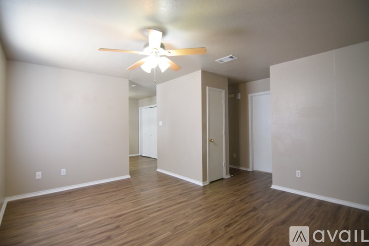 A room with a ceiling fan and wooden floors.
