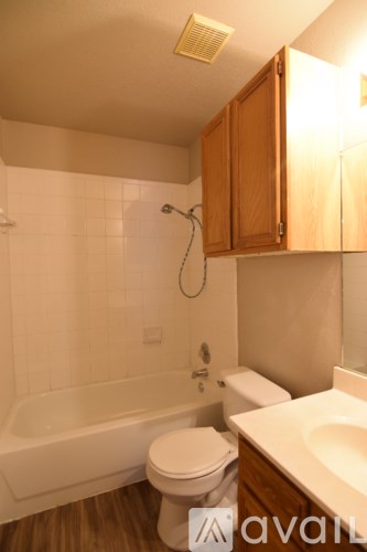 A bathroom with a white tub, toilet, and sink.