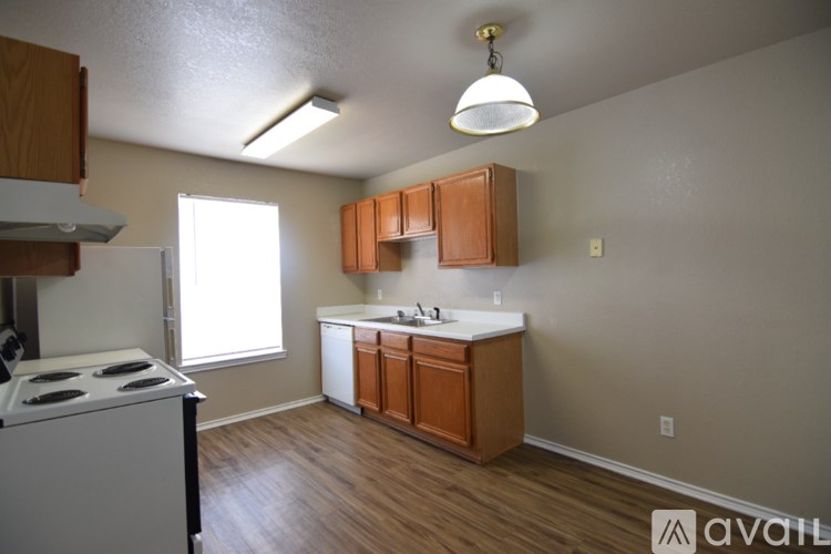 A kitchen with wooden cabinets and a white stove top oven.