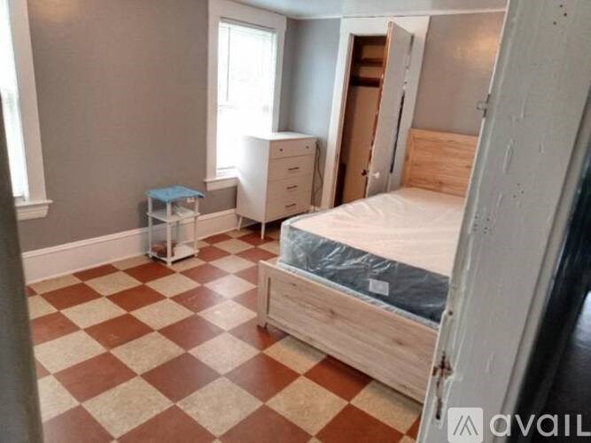 A bedroom with a bed, dresser, and nightstand.