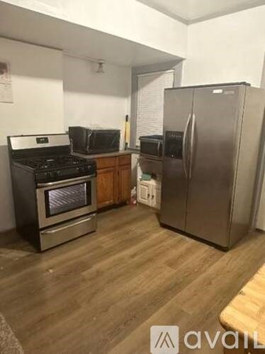 A kitchen with a stainless steel refrigerator and a stove with an oven.