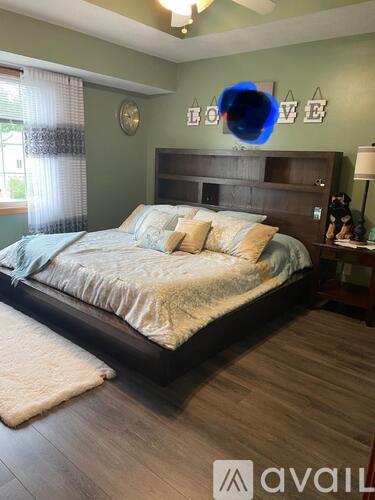 A bedroom with a large bed and a wooden headboard.
