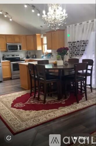 A kitchen with a dining table and chairs.