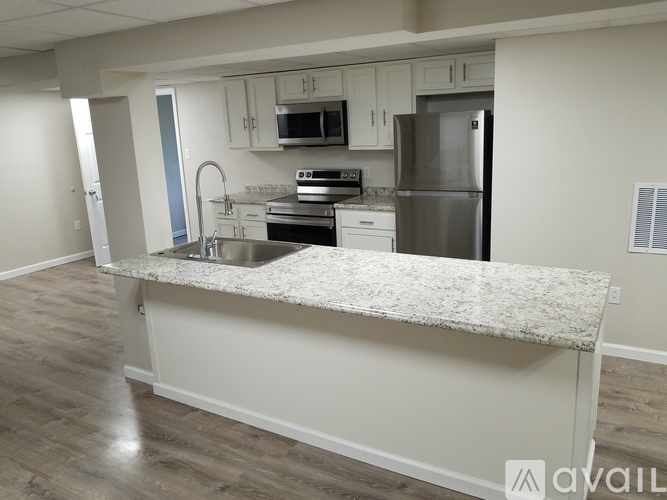 A kitchen with a granite countertop and stainless steel appliances.