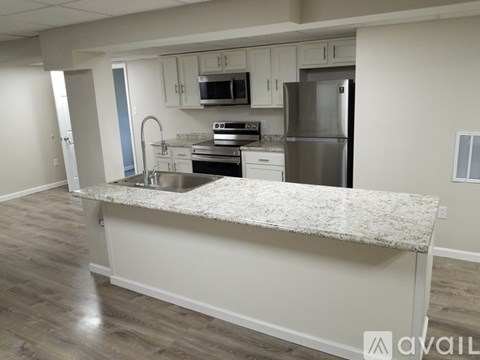 A kitchen with a granite countertop and stainless steel appliances.