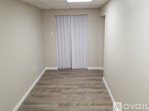 A room with a wooden floor and a white curtain.