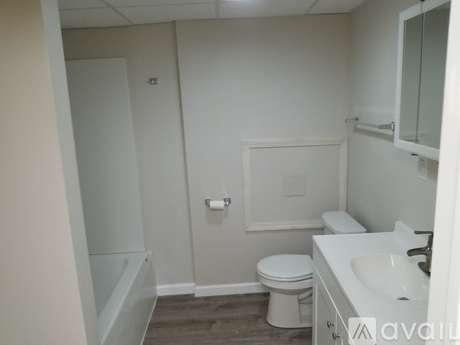 A white bathroom with a toilet, sink, and bathtub.