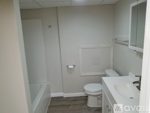 A white bathroom with a toilet, sink, and bathtub.