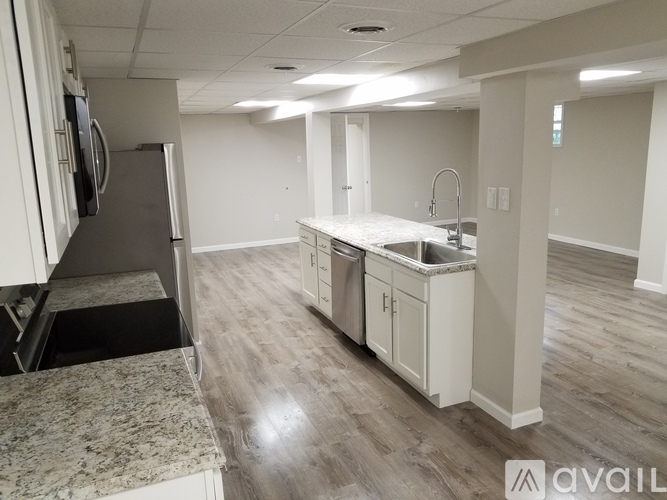 A kitchen with a granite countertop and white cabinets.