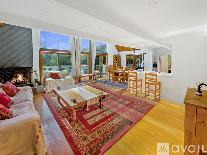 A living room with a fireplace and a rug on the floor.