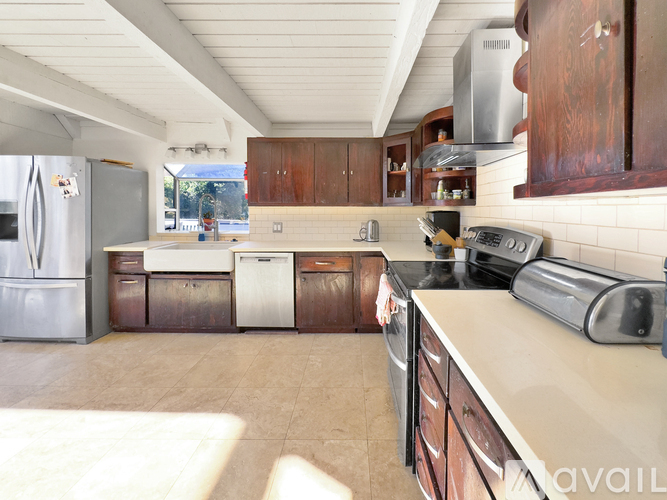 A kitchen with wooden cabinets and a white fridge.