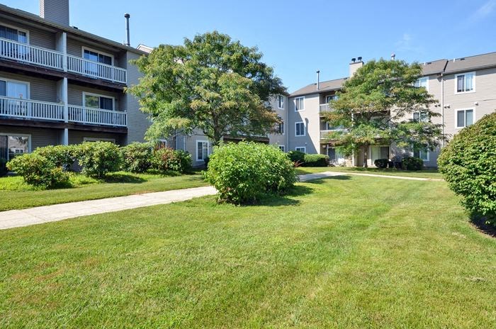 a green lawn in front of an apartment building