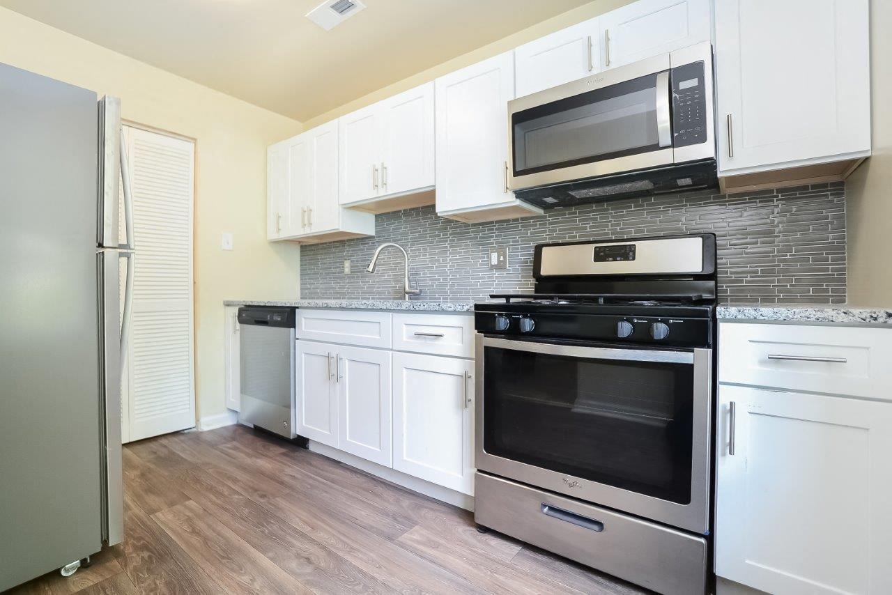A kitchen with white cabinets and stainless steel appliances.