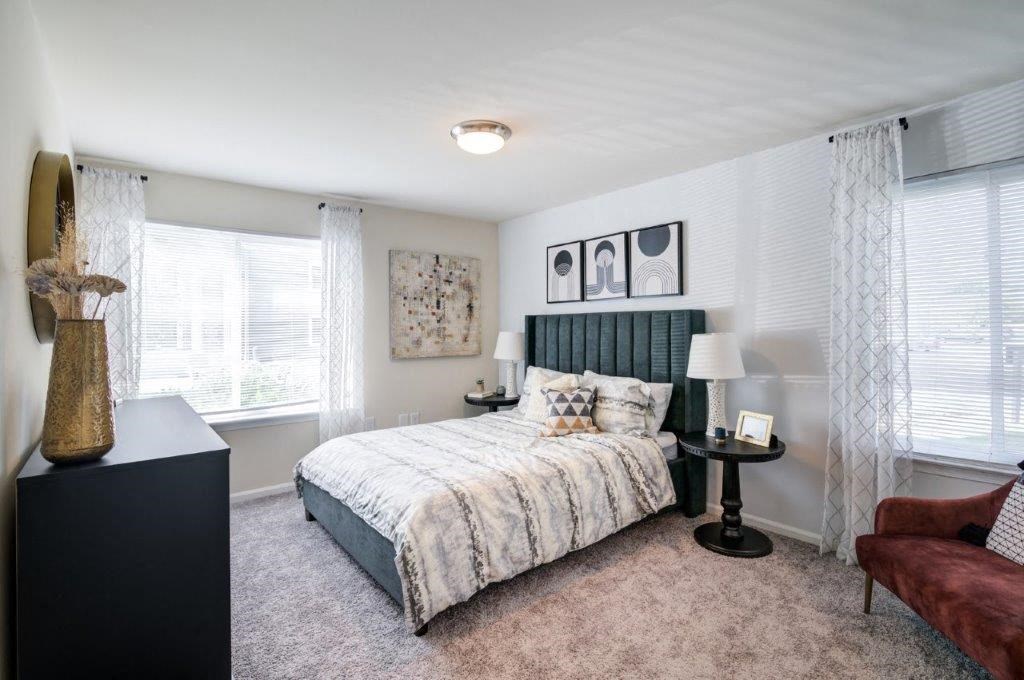 a bedroom with a bed and two windows