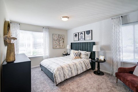 a bedroom with a bed and two windows