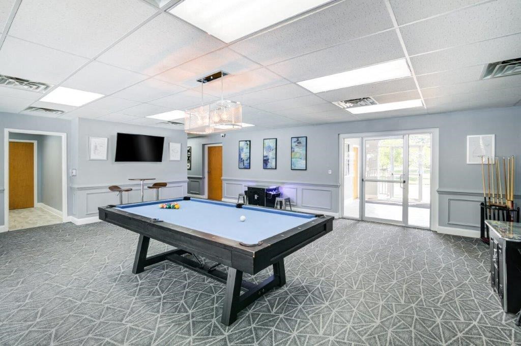 a game room with a pool table and a tv