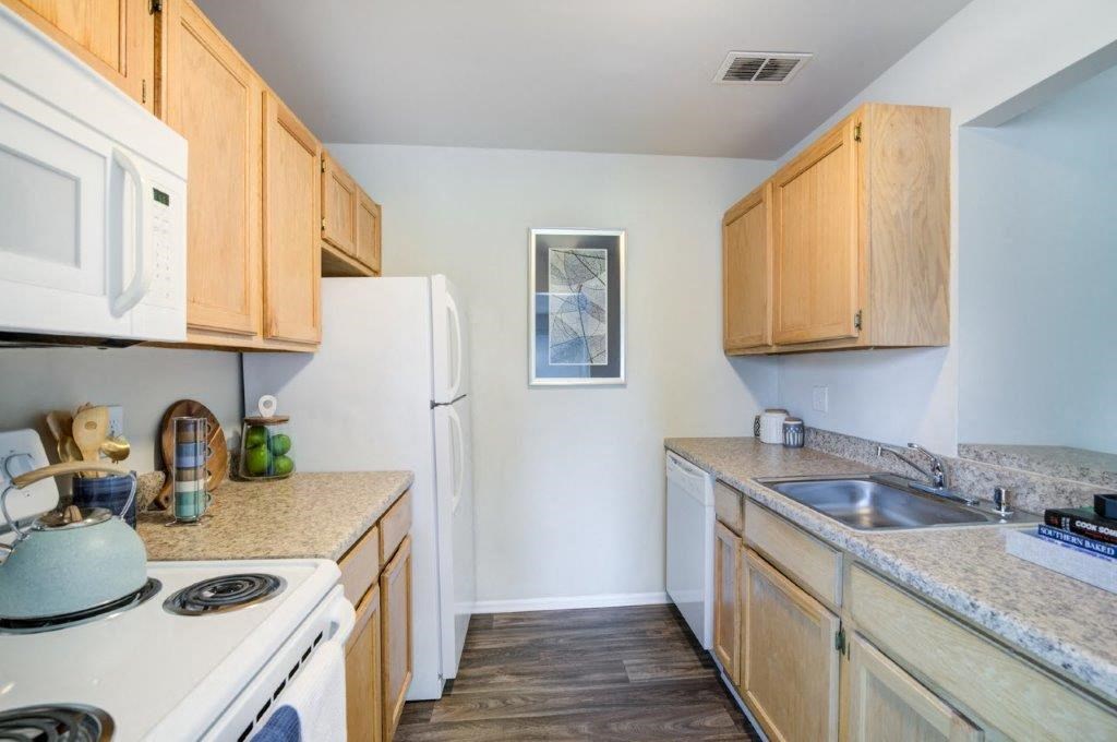 a kitchen with white appliances and wooden cabinets