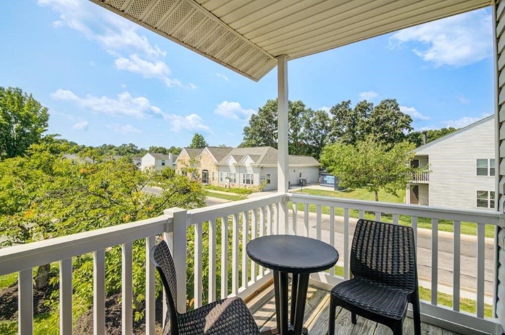 a patio with two chairs and a table on a balcony