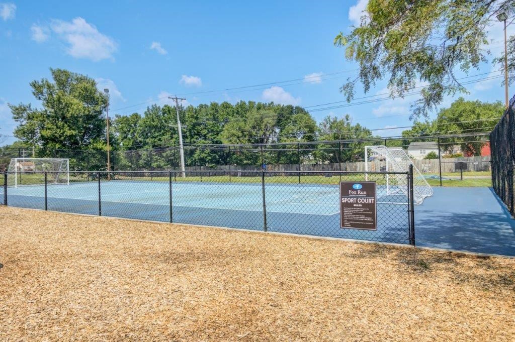 a tennis court at a park with a sign on the fence