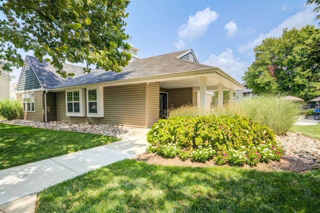 a small brown house with a sidewalk in front of it