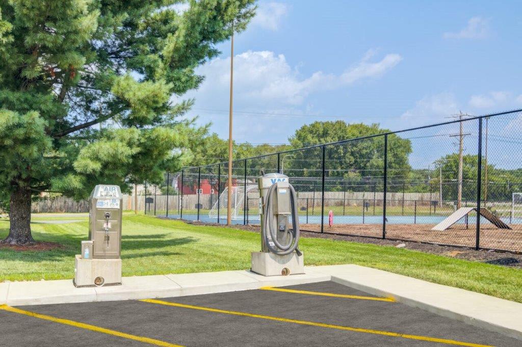 a park with a playground and a statue in front of a fence