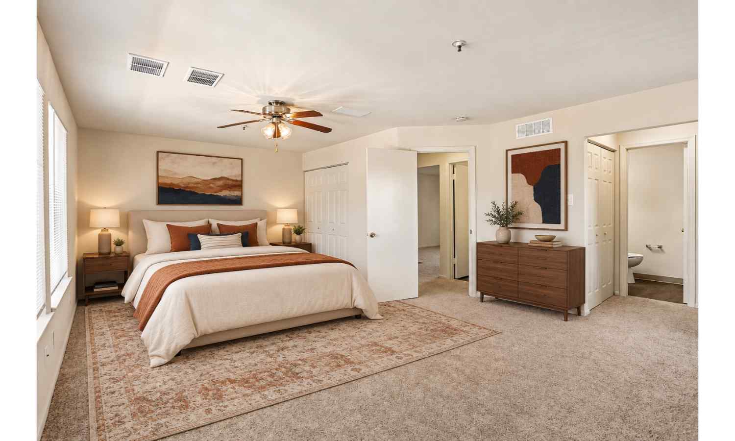 A bedroom with a large bed and a ceiling fan.