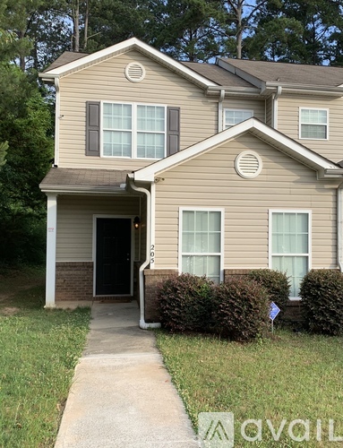A two-story house with a beige siding and a brown roof.