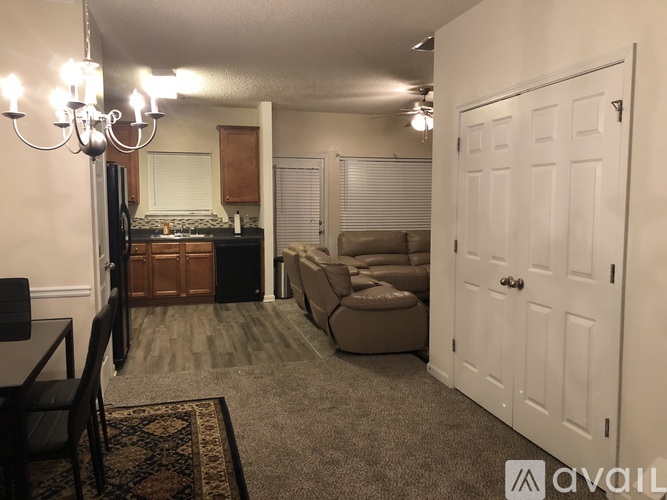 A living room with a couch, a chair, and a rug.