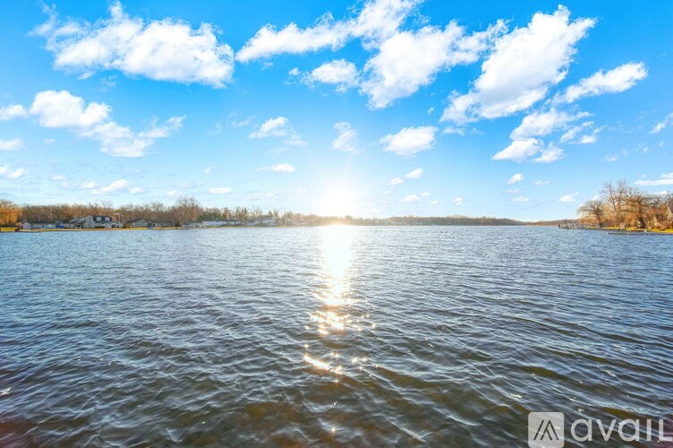 The sun is shining brightly over a calm body of water.