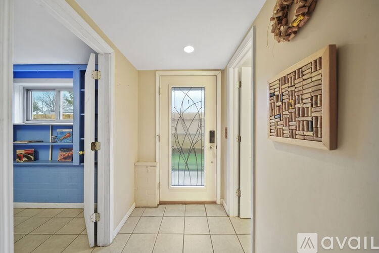 A hallway with a door and a wall hanging.