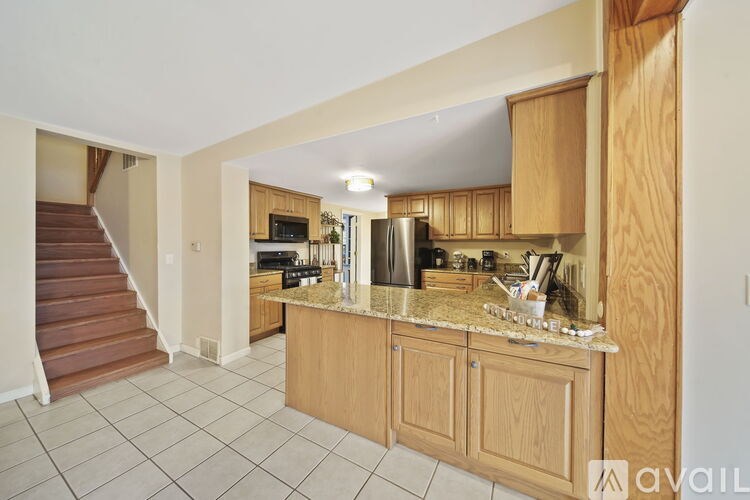 A kitchen with wooden cabinets and a granite countertop.
