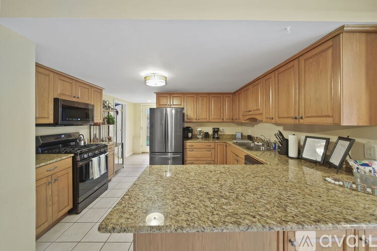 A kitchen with granite countertops and wooden cabinets.