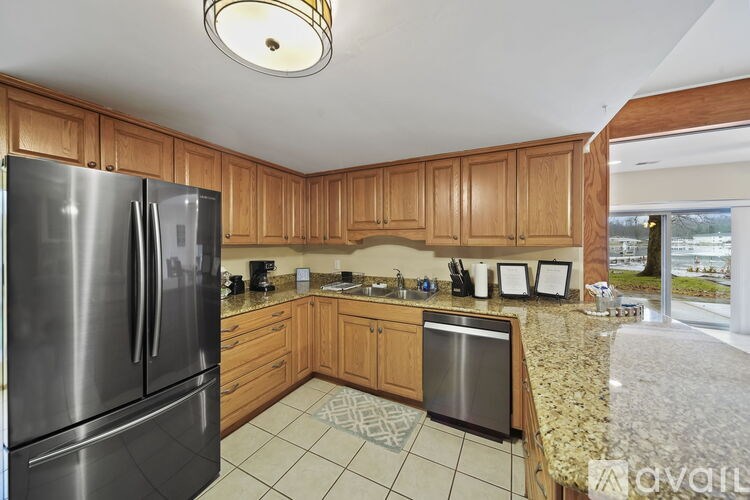 A kitchen with wooden cabinets and a stainless steel refrigerator.