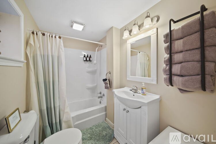 A bathroom with a white tub, sink, and toilet.