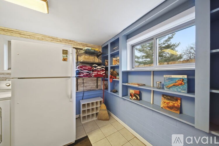 A white refrigerator is in a kitchen with blue walls.