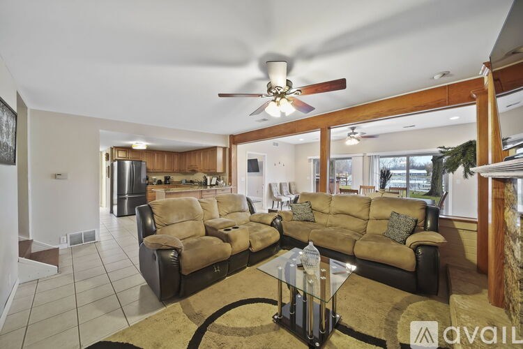 A living room with a brown sofa and a glass coffee table.