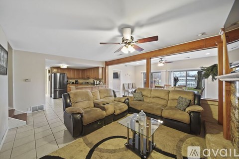 A living room with a brown sofa and a glass coffee table.