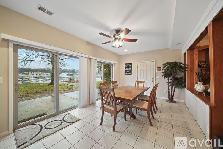 A dining room with a table and chairs and a ceiling fan.