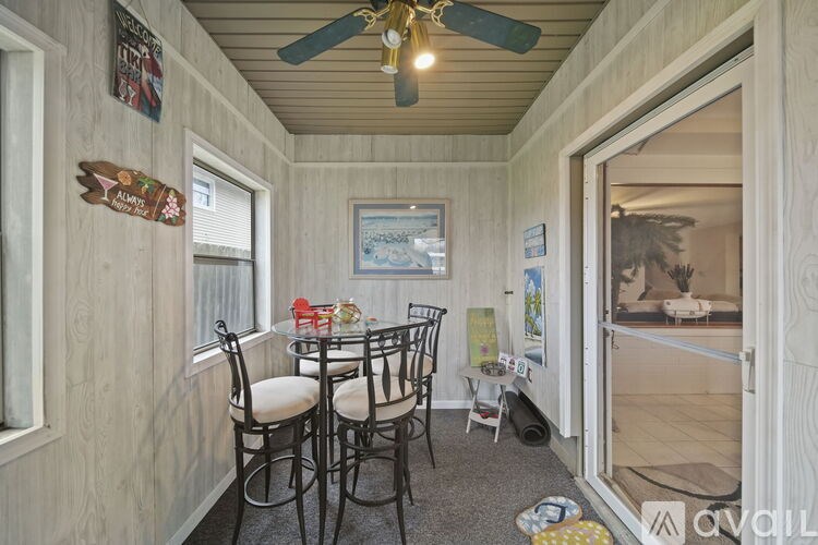 A room with a table and chairs and a ceiling fan.