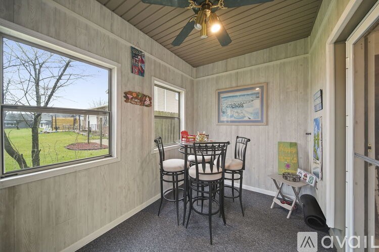 A room with a table and chairs and a window.