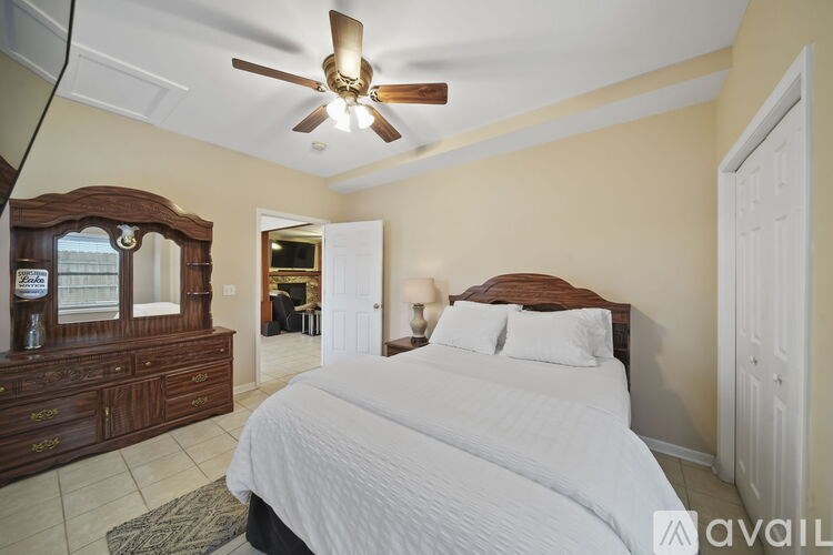 A bedroom with a large bed and a ceiling fan.