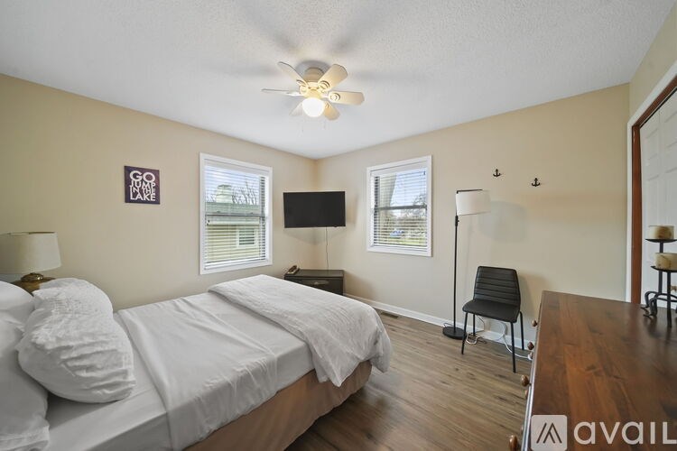 A bedroom with a bed, a chair, and a television.