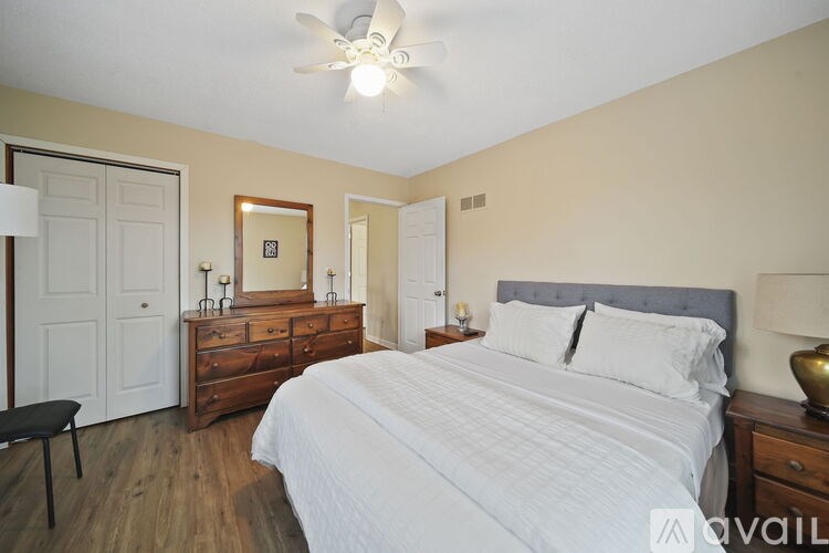 A bedroom with a bed, dresser, and mirror.